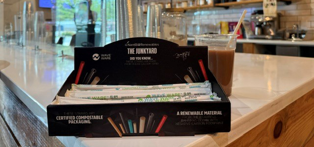 Wave Ware compostable straws display and glass of iced drink at The Junk Yard Fitness café.