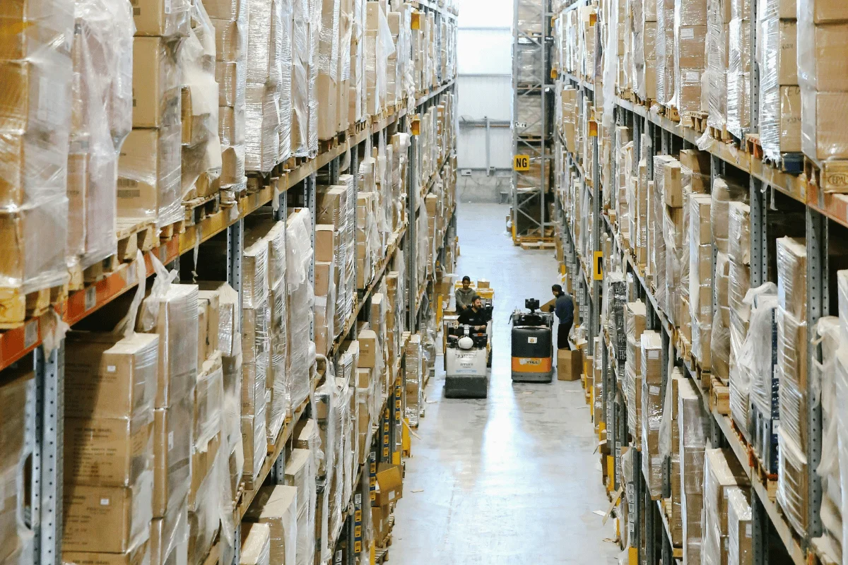 A spacious warehouse with tall shelves stacked with boxes.