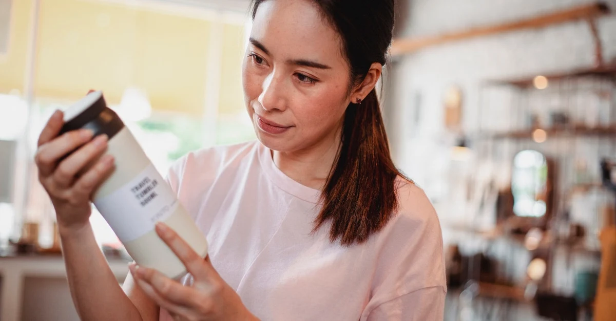 Woman examining compostable product label, illustrating mislabeling compliance risks for distributors.
