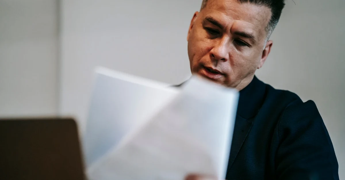 Man reviewing documents related to supplier accountability and environmental certifications.