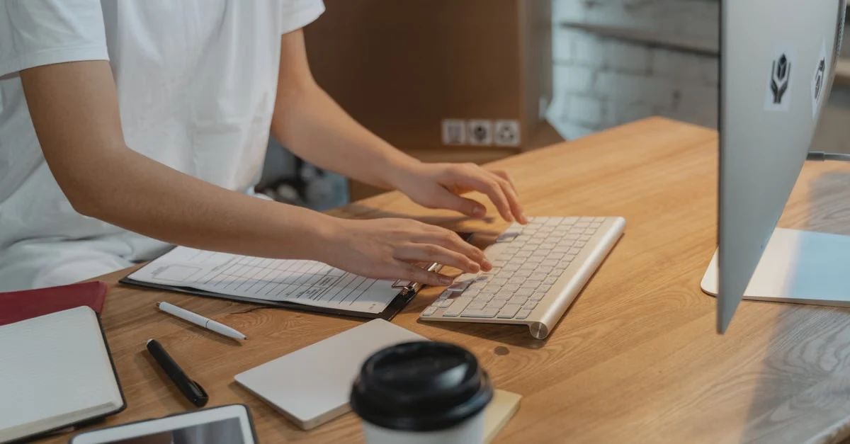 Professional reviewing stacked compliance documents with pen, ensuring compostable products sourcing meets state regulations.