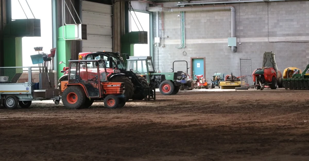 Red telehandler in industrial composting facility with machinery and compostable packaging certifications testing equipment.